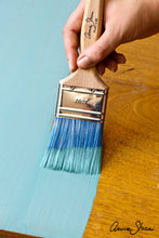 Load image into Gallery viewer, Annie Sloan's Flat Brushes feature advanced synthetic fibres, in a vibrant blue, which help to produce a smooth, contemporary finish. The Brushes are designed to take a large amount of paint and to apply the paint evenly, minimising brush marks.  Available in small (23cm x 3cm) and large (26cm x 6cm).