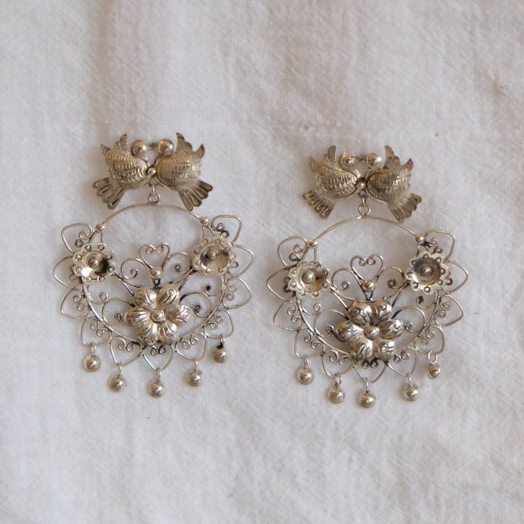 These beautiful Mazahua earrings were created by artisans in central Mexico. Made of silver, they are handcrafted using ancient techniques and feature an intricate, traditional design. 