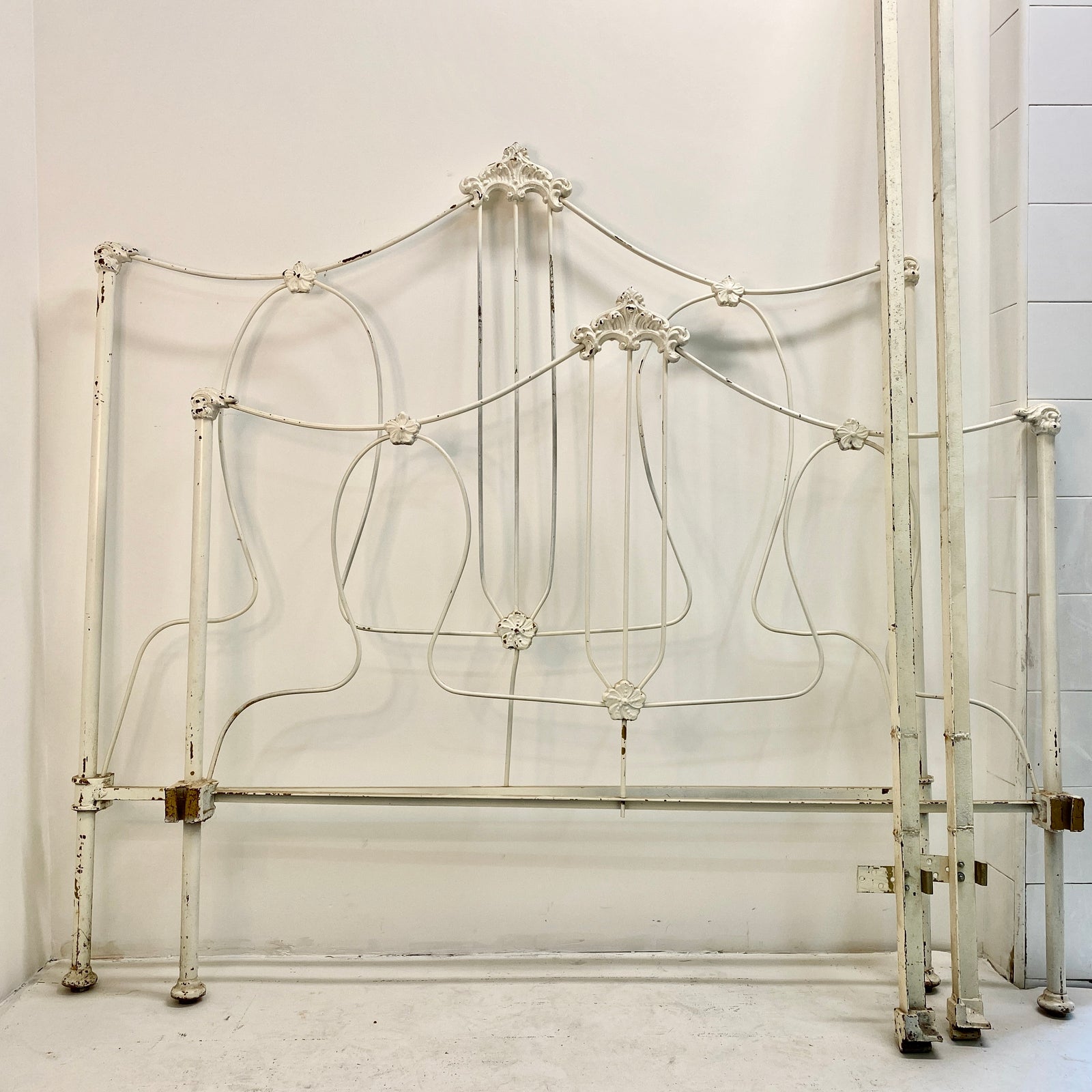 With sweet floral details and a thin but sturdy metal build, this vintage bedframe is both playful and sophisticated. Includes a headboard, footboard, and side rails.  Pick up or local delivery only. Come by the shop to see this one-of-a-kind piece in person!   Dimensions: Headboard: H 54" x W 78.5" x D 53". Footboard:  H 45" x W 78.5" x D 53". Interior will accommodate a full-sized mattress Iron     