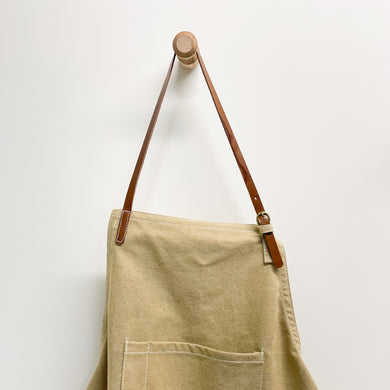 This durable canvas apron features brown leather straps and multiple pockets. With plenty of room for recipe cards, a phone, and a small towel, never be too far away from the items you need most. Perfect for cooking, crafts, or projects around the home.