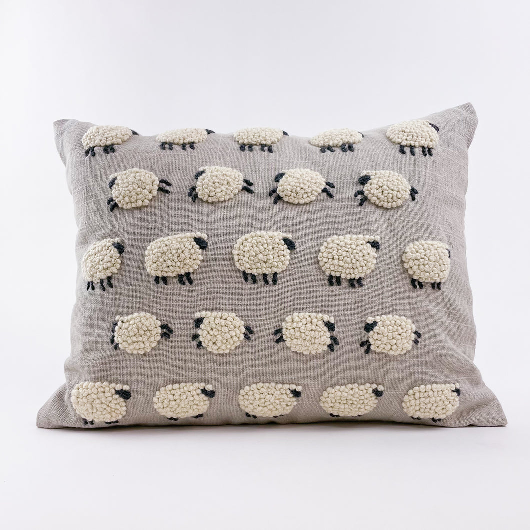This beautiful pillow with embroidered and applique sheep is perfect for a nursery or child's bedroom. Evocative of Princess Diana's iconic sheep sweater from Rowing Blazers, it could also add a touch of whimsy to any living room.  Material: 100% cotton. Sold with insert. Dry clean only.  Dimensions: 12
