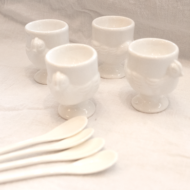 This set of four porcelain egg cups and spoons is perfect for your breakfast and brunch needs. It's chicken design makes them super fun to have on your table. Enjoy this set of four at your next event.   Product Material:  Porcelain  Dimensions:  D2.75 X 2 X 3